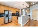 Contemporary kitchen features stainless steel appliances, wooden cabinets, black backsplash, and a stylish island at 361 17Th St # 1516, Atlanta, GA 30363