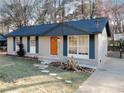 Cozy brick home with an orange front door, large front window, and basketball hoop at 8325 Attleboro Dr, Jonesboro, GA 30238