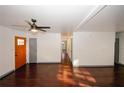 Open-concept living room with hardwood floors, modern ceiling fan, and a bright orange door at 8325 Attleboro Dr, Jonesboro, GA 30238