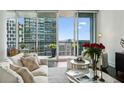 Bright living room with floor-to-ceiling windows and a balcony offering stunning city views at 1080 Peachtree Ne St # 2309, Atlanta, GA 30309