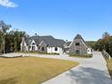 Elegant two-story home featuring a stone and brick facade, expansive lawn, and circular driveway at 4100 Oak Hill Rd, Douglasville, GA 30135