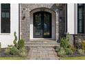 Close-up of the arched front entrance with intricate wrought iron double doors and stone walkway at 4100 Oak Hill Rd, Douglasville, GA 30135