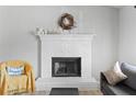 A lovely fireplace with a white brick surround and wooden mantle creates a cozy focal point at 951 Orchard Mill Ln, Lawrenceville, GA 30043