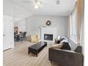 Cozy living room featuring a fireplace, vaulted ceilings, modern ceiling fan, and beautiful natural light at 951 Orchard Mill Ln, Lawrenceville, GA 30043