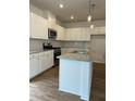 Bright kitchen features white cabinets, stainless steel appliances, granite countertops, and an island at 202 Groveton Ct, Euharlee, GA 30145