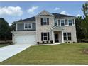 Charming two-story home featuring a brick and siding facade, an attached garage, and a well-manicured lawn at 3166 Morris Hills Dr, Dacula, GA 30019