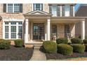 Inviting front porch with white columns and double doors, complemented by manicured landscaping at 4240 Agard St, Cumming, GA 30040
