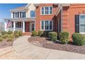 Beautiful two-story house with American flag, brick facade, trimmed shrubs, and lovely stone-lined sidewalk at 408 Hickory Fairway Ct, Woodstock, GA 30188