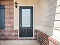 Close-up of the front door featuring a brick facade and classic black entry at 9109 Alden Dr, Locust Grove, GA 30248