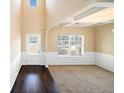 Bright, high ceilinged living room with dark hardwood floors and a large window at 9109 Alden Dr, Locust Grove, GA 30248