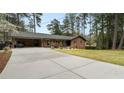 Long concrete driveway leads to brick home with covered carport and manicured lawn at 3504 Palace Ct, Tucker, GA 30084