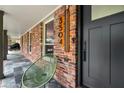 Covered porch with slate tile, brick wall, modern house numbers, and matte black door at 3504 Palace Ct, Tucker, GA 30084