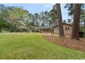 Sprawling front yard view of brick home with mature trees and meticulously maintained lawn at 3504 Palace Ct, Tucker, GA 30084