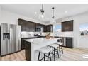 Stylish kitchen featuring stainless steel appliances, a center island, and dark cabinetry at 3136 Morris Hills Dr, Dacula, GA 30019
