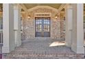 Elegant brick facade and double front door with sidelights, flanked by stately columns and lighting at 511 Millwood Ct, Canton, GA 30114