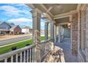 View of front porch with white columns, brick floor, and neighborhood view at 511 Millwood Ct, Canton, GA 30114