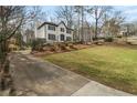 View of a home with a long driveway, two stories, black shutters and door, and a well manicured lawn at 1936 Oak Ridge Ct, Marietta, GA 30062