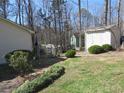 The expansive backyard features a deck with a grill, lush greenery, and a storage shed, offering ample space for outdoor activities at 86 Kelly Ct, Dallas, GA 30157