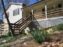This home's front exterior showcases beautiful landscaping and a wooden staircase leading up to the charming front porch at 86 Kelly Ct, Dallas, GA 30157
