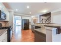 Well-lit kitchen featuring stainless steel appliances, tile backsplash, and hardwood floors at 215 Aldridge Pl # 9, Smyrna, GA 30082