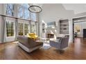 Sun-filled living room with large windows, fireplace, and hardwood floors at 3493 Maryhill Nw Ln, Kennesaw, GA 30152