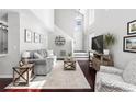 Bright living room featuring a soaring ceiling, hardwood floors, and a neutral color palette at 503 Stanford Pl, Woodstock, GA 30188