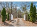 Stone and white wood driveway gate surrounded by landscaping leading into property at 5515 Punkintown Rd, Douglasville, GA 30135