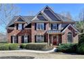 Beautiful two-story brick home with a manicured lawn, mature landscaping, and a welcoming front entrance at 5030 New Chapel Hill Way, Cumming, GA 30041