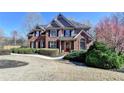 Inviting brick home showcasing mature landscaping and a well-manicured front yard at 5030 New Chapel Hill Way, Cumming, GA 30041