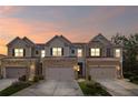 Exterior view of charming townhomes at sunset, showcasing the attached garages at 5975 Vista Brook Dr, Suwanee, GA 30024