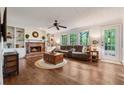 Cozy living room with fireplace, built-in shelving, ceiling fan, and hardwood floors at 1061 Steeple Run, Lawrenceville, GA 30043