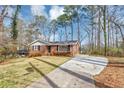 Beautiful one-story brick home with a long driveway and a well-maintained front lawn at 2718 Amelia Ave, Decatur, GA 30032