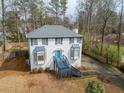 Two-story home with blue door and trim, featuring bay windows, mature trees, and a welcoming facade at 4646 Breakwater Trl, Marietta, GA 30066