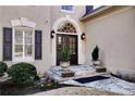 Elegant front entrance with stone steps, potted plants, and stylish lighting fixtures at 9290 Waits Ferry Xing, Duluth, GA 30097