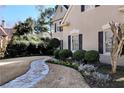 Landscaped front yard with stone pathway, flowerbeds, and manicured shrubs enhancing curb appeal at 9290 Waits Ferry Xing, Duluth, GA 30097