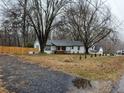 Inviting exterior view of a well-maintained home with a fenced yard and mature trees at 3250 Lee Dr, Buford, GA 30518