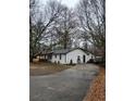 A well-maintained home featuring a long driveway and a neatly landscaped yard with mature trees at 3250 Lee Dr, Buford, GA 30518