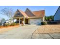 Well-kept home showcasing a spacious driveway and a tidy front yard with mature landscaping at 422 Windy Ridge Way, Canton, GA 30114