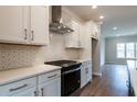 A chef-ready kitchen with stainless steel range, bright white cabinets, and stone countertops at 4826 Floydwood Ln, Mableton, GA 30126