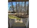 View from the covered front porch showcases the peaceful, tree-lined surroundings at 2087 Blackberry Ln, Auburn, GA 30011