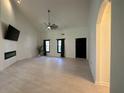 Spacious living room with a modern fireplace, sleek ceiling fan, and large windows for natural light at 2087 Blackberry Ln, Auburn, GA 30011