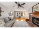 Bright living room with hardwood floors, large windows, comfortable sofa, and brick fireplace at 4112 Gregory Manor Sw Cir, Smyrna, GA 30082