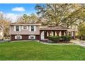 Charming split-level home with brick facade, landscaped front yard, and covered porch at 2670 Foxlair Trl, Atlanta, GA 30349