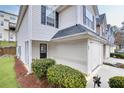 Exterior angle view of a townhome with attached garage, landscaping, and side entrance at 6730 Gallant Se Ct, Mableton, GA 30126