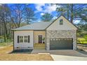 Charming single-Gathering home featuring stone accents, attached garage, and welcoming entrance at 6971 Tan Bark Ct, Riverdale, GA 30296