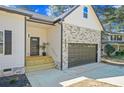 Inviting front entrance features a two-car attached garage and stylish stone detailing at 6971 Tan Bark Ct, Riverdale, GA 30296