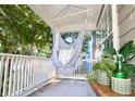 Relaxing front porch featuring hanging hammock chair and potted plants at 733 Rice Nw St, Atlanta, GA 30318