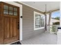 View of front porch with a hanging hammock chair and wooden front door at 733 Rice Nw St, Atlanta, GA 30318