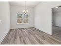 Dining room with wood-look floors, a window overlooking the yard, and modern chandelier at 1235 Cedarcrest Blvd, Acworth, GA 30101