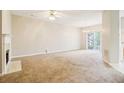Spacious living room featuring plush carpet, fireplace, and sliding glass doors to the backyard at 1624 River Main Ct, Lawrenceville, GA 30046